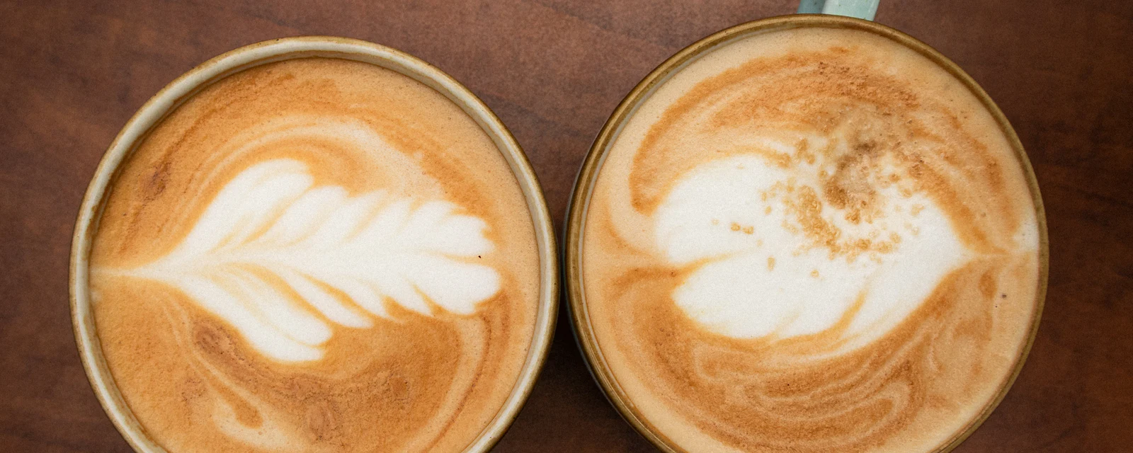 Zwei Tassen Cappuccino auf einem Holztisch